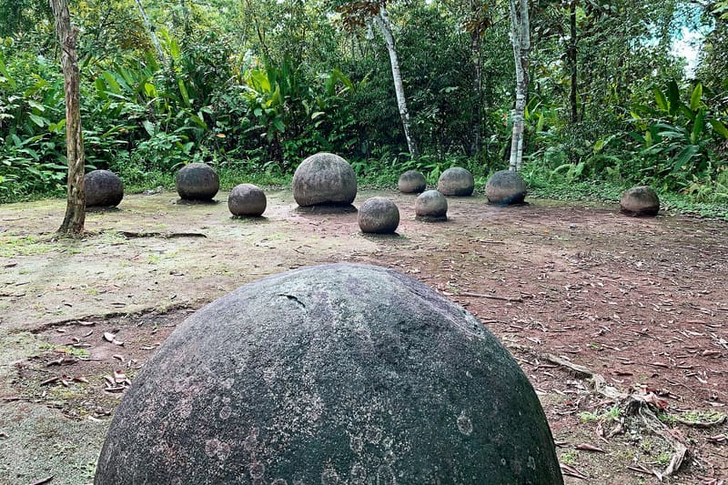 A branded card in deep burgundy introducing an article about the pre-Columbian stone spheres of Costa Rica.