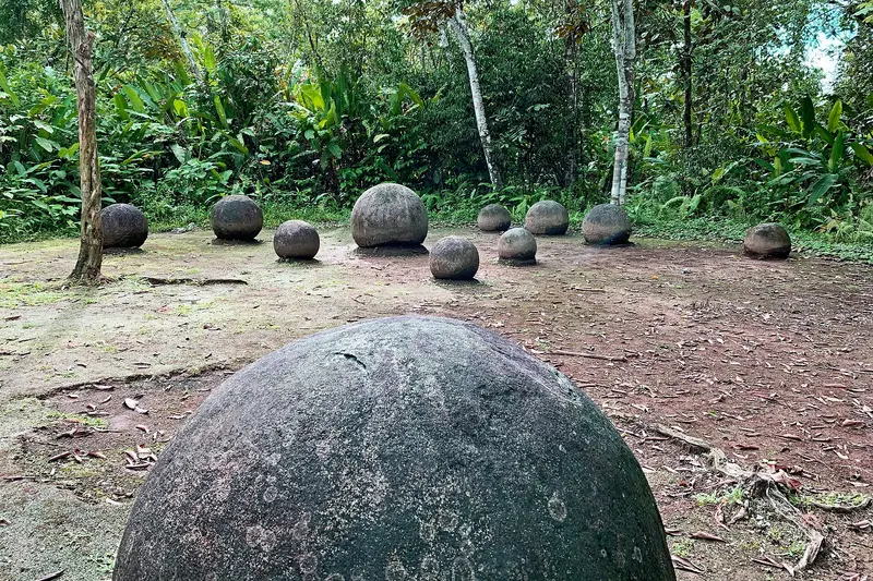 A branded card in deep burgundy introducing an article about the pre-Columbian stone spheres of Costa Rica.